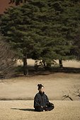 Girl meditating in a park in winter Tokyo Japan  [AT]