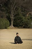 Girl meditating in a park in winter Tokyo Japan  [AT]