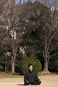 Girl meditating in a park in winter Tokyo Japan  [AT]