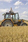 Young farmer practising yoga on his tractor's cabin France