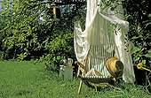 Long chair under a mosquito net in a private garden  France
