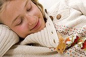 Girl with an outgoing gilded hamster of the collar of its sweater