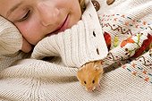 Girl with an outgoing gilded hamster of the collar of its sweater
