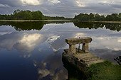 Etang après l'orage au printemps Dombes France ; Au premier plan, la vanne (le thou) servant à réguler le niveau d'eau.