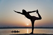 Man in a yoga posture at the edge of the Ganges India