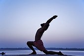 Indian man in yoga posture near the Ganges India