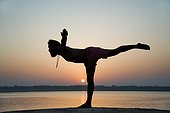 Indian man in yoga posture near the Ganges India