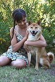 Girl and Shiba Inu seated in a garden France 