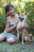 Girl and Shiba Inu seated in a garden France 