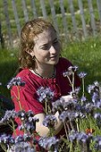 Young red-haired girl and lacy phacelia in a garden