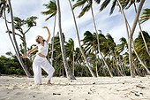 Woman praticing yoga on a beach in Martinique Island