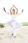 Woman and man praticing yoga on a beach in Martinique Island