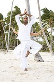 Woman and man praticing yoga on a beach in Martinique Island
