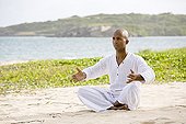Man praticing yoga on a beach in Martinique Island