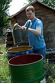 Young man filling a watering can in a kitchen garden