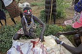 Group of persons during the Pokot Sapana Ceremony Kenya ; The Pokot people, warrior and pastor nomads based in the north of the Baringo lake, express their wealth through their cattle possessions. Adolescents (17 to 20 years old) become adults during the Sapana ceremony, for which young warriors sacrifice one of their cows to offer the meat and blood to their family and to their future wife’s families. Then, young men recover cowpat in innards and put on all their bodies. Dances and battle pretences follow one another all day long.