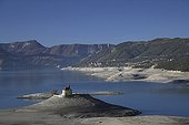 Chapelle Saint-Michel dans le lac de Serre-Ponçon France ; Lorsque le niveau de l'eau du lac baisse, la chapelle Saint-Michel est accessible à pieds, alors qu'en temps normal, elle est entourée d'eau.