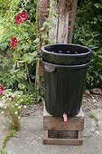 Making of Russian comfrey juice in a garden ; 2 - Fit together the one with holes on the top of the one with tap
