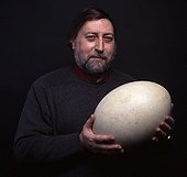 Man carrying an Elephant bird Egg ; Volume of the egg, eight liters<br>Character: Jacques Maigret 