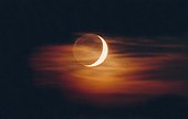 Earthshine a crescent moon and sail Cirrus ; A crescent moon accompanies his Earthshine is masked by a veil of cirrus also dons orange hues of sunset moon. 