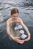 Young woman and pumice stone floating in the sea Lipari 