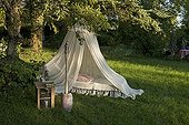 Mosquito net over a bed in a garden