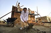 Man preparing cement, construction of brick houses for families whose houses were destroyed during the flood catastrophe of 2010, Lashari Wala village near Muzaffaragarh, Punjab, Pakistan, Asia
