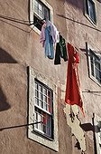 Laundry hanging to dry on a line in front of a house with crumbling plaster walls in the district of Alfama, Lisbon, Portugal, Europe