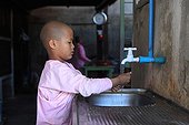 Nun washing hands in Nyaung Shwe Burma ; Otama, a young nun of 10 years