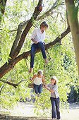 Smiling little siblings playing in tree swing