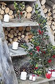 holly and candles on a ladder in a garden