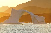Groenland. Côte ouest. Coucher de soleil sur un iceberg en forme d'arche dans le détroit de Vaigat, près du village de Saqqaq