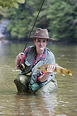 Young woman presenting a wild Trout of the Doubs (Salmo trutta fario), Fly fishermen on the French-Swiss Doubs river, La Goule, Franche-Comté, France