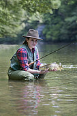 Young woman presenting a wild Trout of the Doubs (Salmo trutta fario), Fly fishermen on the French-Swiss Doubs river, La Goule, Franche-Comté, France