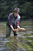 Young woman presenting a wild Trout of the Doubs (Salmo trutta fario), Fly fishermen on the French-Swiss Doubs river, La Goule, Franche-Comté, France