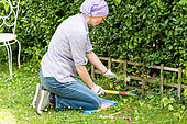 Women cleaning a border. She is using a kneeling mat