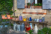 Collection of watering cans on a bench, Provence, France