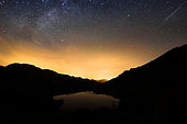 First light of dawn on the lake of the fairies, the stars are still visible, as well as a shooting star, Massif du Beaufortain, Savoie, Alps, France