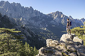 Laricio pine forest (Pinus Nigra Corsicana) of the Bavella pass (1218m), young hiker contemplating the aiguilles of Bavella (max alt: 1855m), Alta Rocca, Quenza, Corse-du-Sud, France