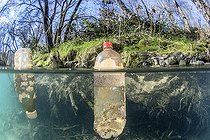 Half-air, half-water view of plastic bottles floating in the Lez river, Hérault, Occitanie, France