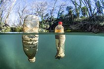 Half-air, half-water view of plastic bottles floating in the Lez river, Hérault, Occitanie, France