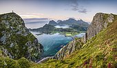 Tiny person stands at the summit and looks out over the wide sea, at the back Lofoten mountains, Offersoykammen, Leknes, Lofoten, Nordland, Norway, Europe