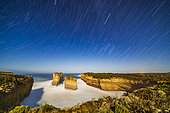Orion (right) and Sirius (upper right) setting into the west over Loch Ard Gorge on the Great Ocean Road, Victoria, Australia, with illumination from the rising moon a day past full behind the camera to the east. . . This is a stack of 100 exposures for the sky and water, each 15 seconds, with the ground coming from one frame in the sequence to prevent the moving shadows from the rising moon from blurring detail.