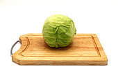 Head of cabbage on a wooden cutting board on a light background. Natural product. Natural color. Close-up.