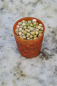 Peas soaking in a glass of water before sowing in the garden