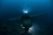 Japanese Navy Seaplane wreck lit by HMI lights with diver hovering above, Palau, Micronesia.