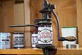 Traditional manual crimping machine, canning maple syrup and closing the cans in a sugar shack at sugar time, Saint-Barthélemy, Lanaudière, Quebec, Canada