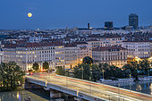 General view of the city of Lyon with buildings in the 6th arrondissement and a summer super full moon in August, Lyon, France.