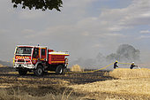 Following a period of extreme heat, a fire ravages a cereal plot: barley in the foreground and wheat in the distance, firefighters intervene to stop the fire. France Damage, loss, danger, insurance, appraisal, compensation problems