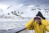 A guide on the lookout for polar bears. Landscape of Svalbard in Norway, also known as Spitsbergen. This territory stretches from latitude 75 to 80 degrees to the pack ice a few hundred kilometers from the North Pole.